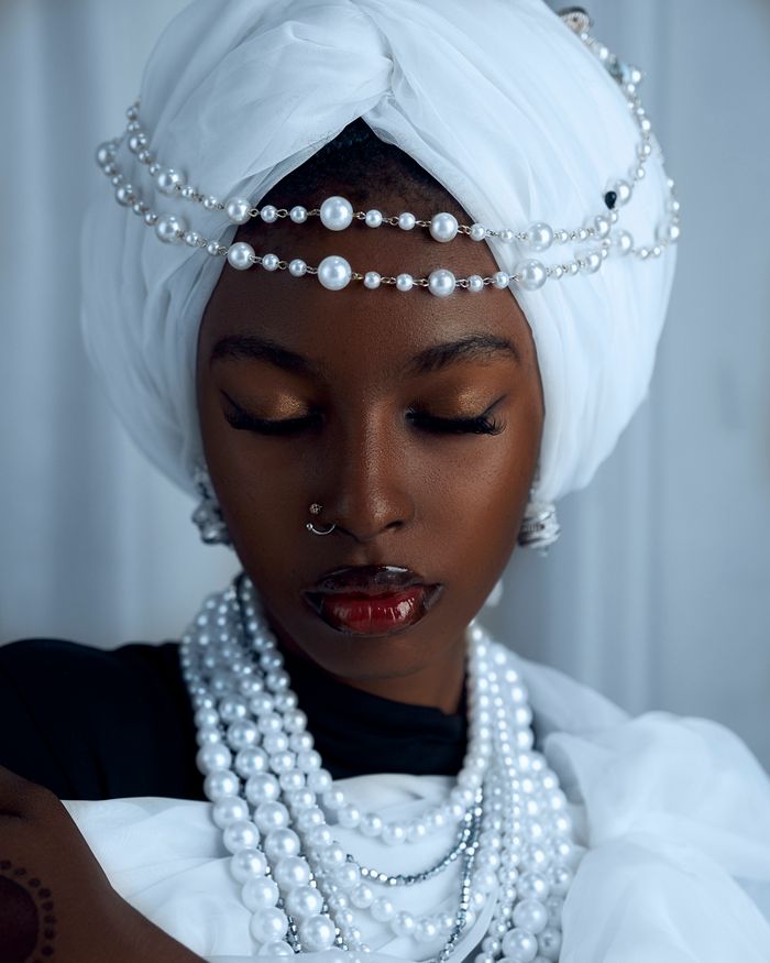 Sophisticated portrait of an adult woman adorned with pearls and turban.